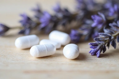 Herbal Sleep Aid capsules on a wooden surface with lavender.